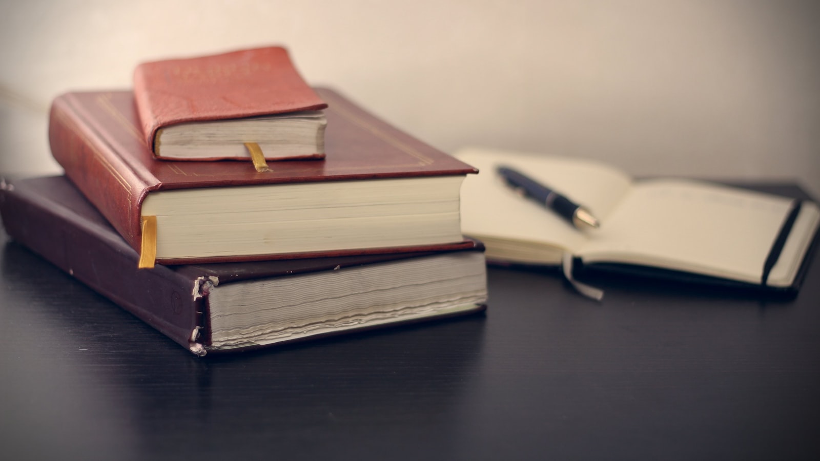 Livros encadernados a couro com caneta e bloco