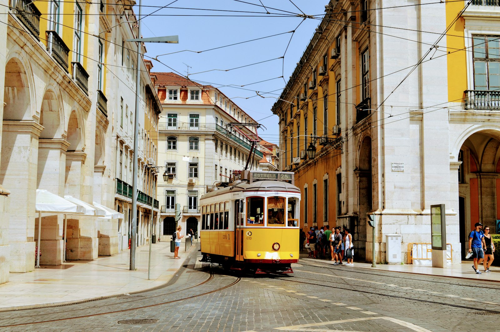 Elétrico amarelo numa rua histórica de Lisboa